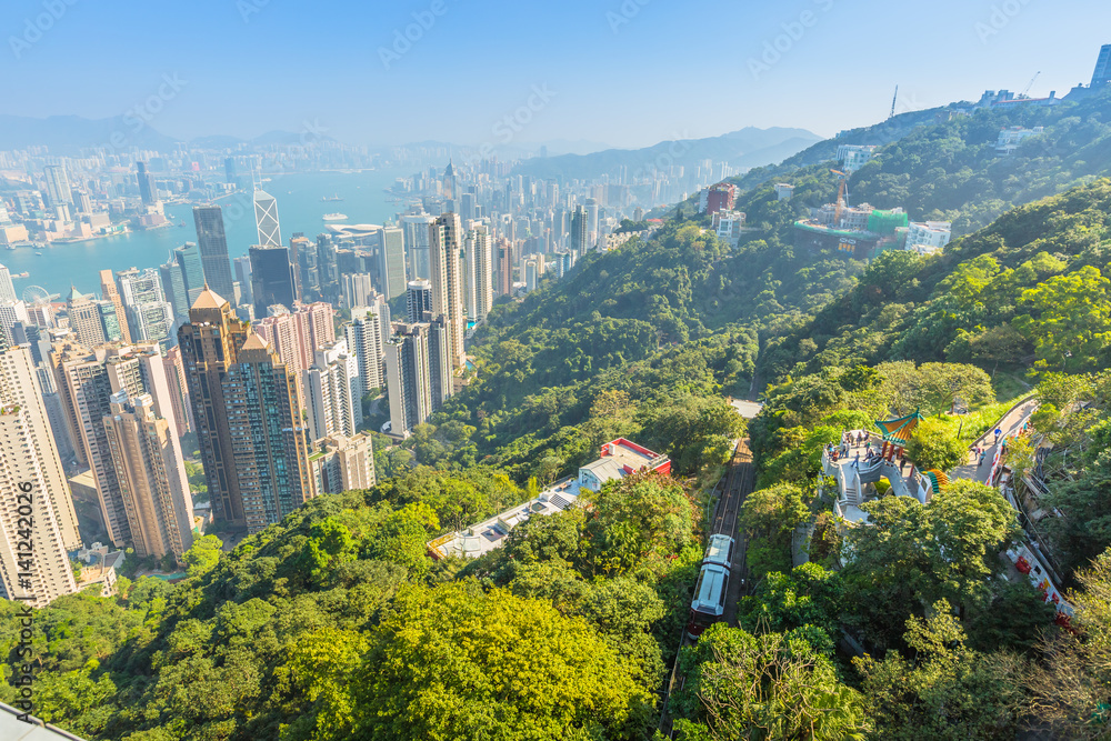 Obraz premium Aerial view of popular Peak Tram from Victoria Peak terrace, the highest peak of Hong Kong island, with panoramic city skyline in background. Sunny day.