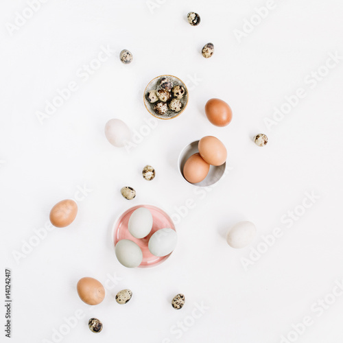 White and brown Easter eggs and quail eggs on white background. Flat lay, top view. Traditional spring concept.