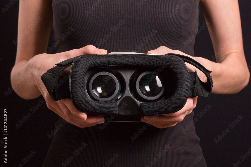 Girl hold modern virtual reality glasses for mobile game application.Close up, focus on vr headset in woman hands Girl hold modern virtual reality glasses for mobile game application.Close up, focus on vr headset in woman hands