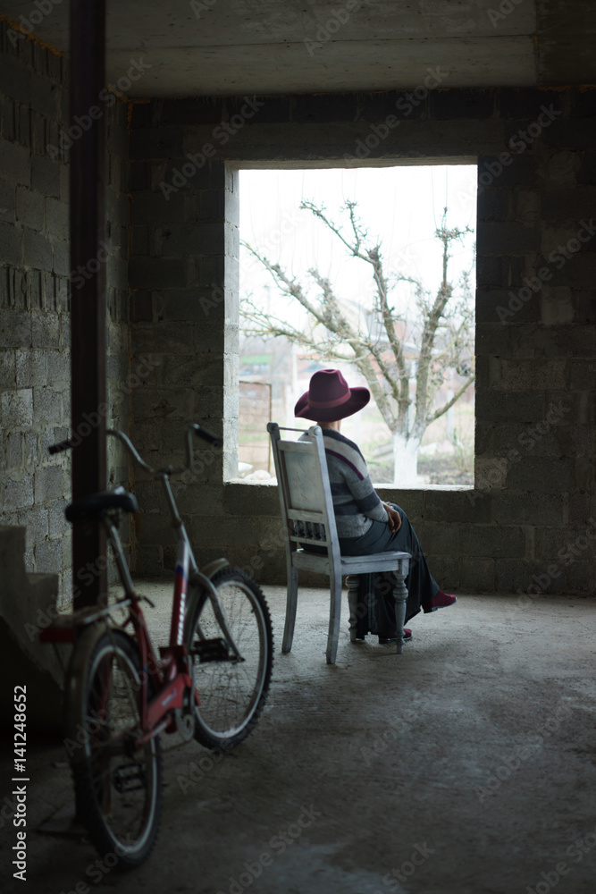 Obraz premium Old lady sit in concrete building