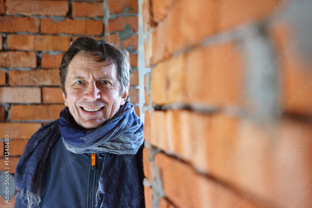Smiling adult man near brick wall Smiling adult man near brick wall
