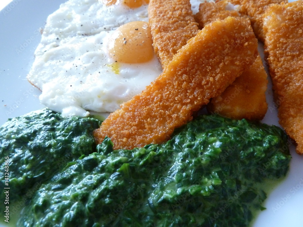 Fischstäbchen, Spinat, Spiegelei Stock-Foto | Adobe Stock