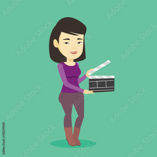 Smiling woman holding an open clapperboard.