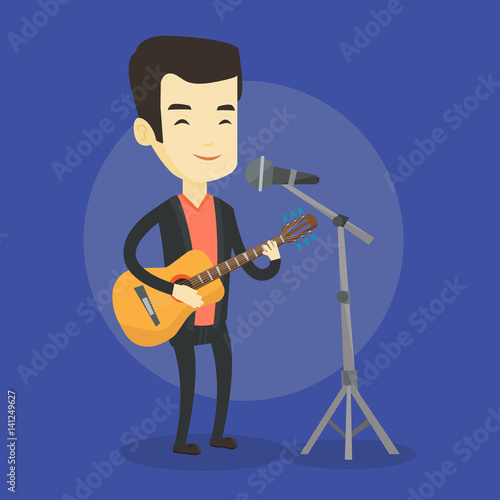 Man singing in microphone and playing guitar.