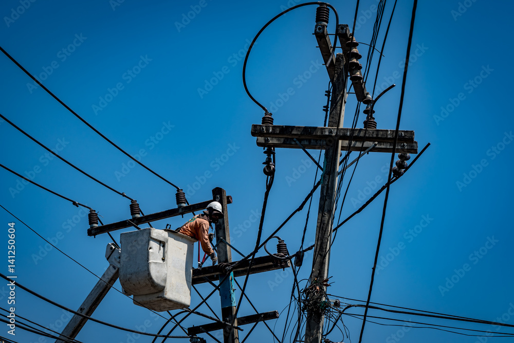 Man working with power line pole
