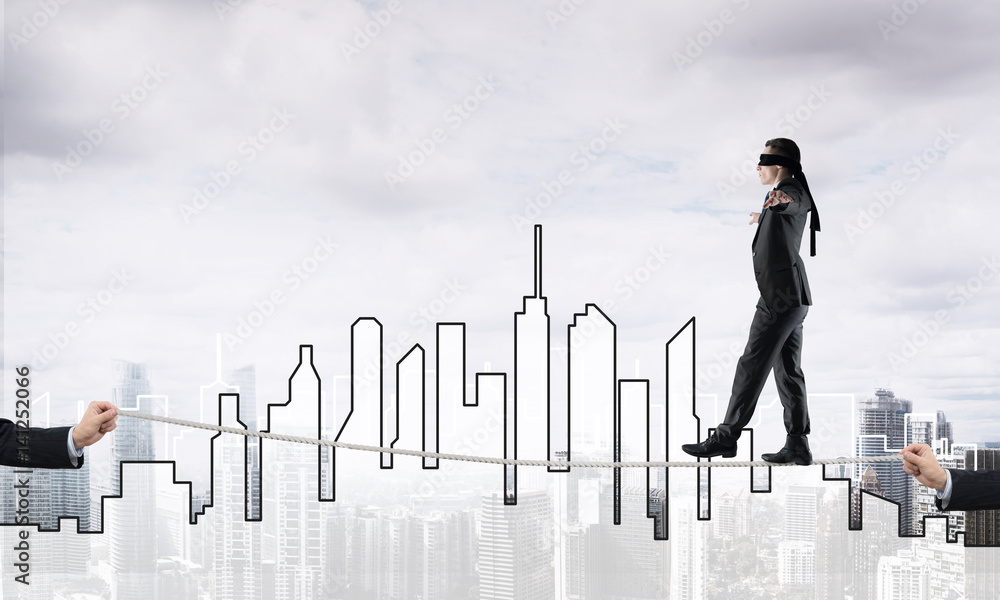 Business concept of risk support and assistance with man balancing on rope Business concept of risk support and assistance with man balancing on rope