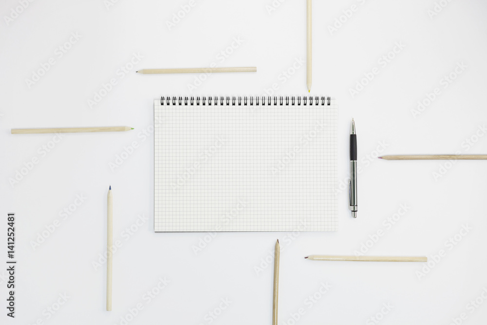 Notebook with pen and pencil on white paper background, for graphic designers presentations and portfolios concept. Notebook with pen and pencil on white paper background, for graphic designers presentations and portfolios concept.