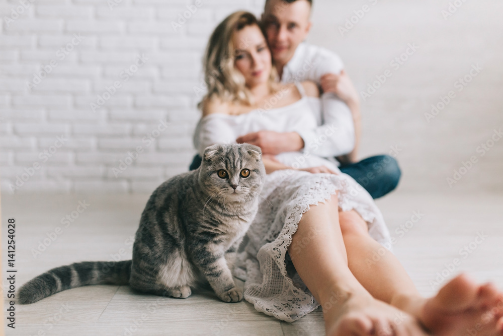 Young couple with scottish fold cat in home. Young couple with scottish fold cat in home.
