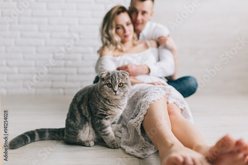 Quadro em tela Young couple with scottish fold cat in home.