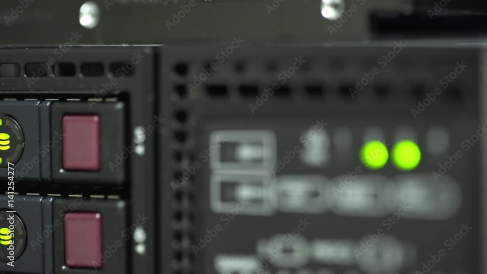 Blinking green LED lights on multiple hard drives of a large network server. Blinking green LED lights on multiple hard drives of a large network server.