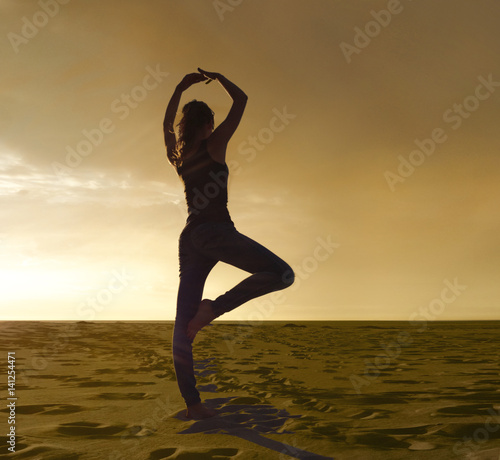 Junge Frau macht  zur Entspannung Yoga Übung am Strand , Figur Baum - vrikshasana photo