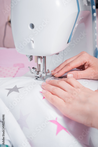Woman's hands with dress at sewing machine