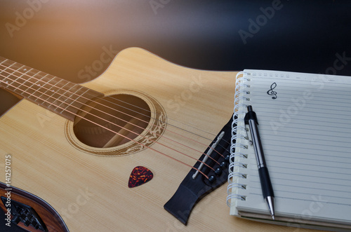 Notebook and pencil on guitar for writing music , Concept of music