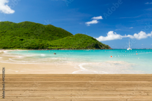 Warm sandy beach in caribbean by wooden decking