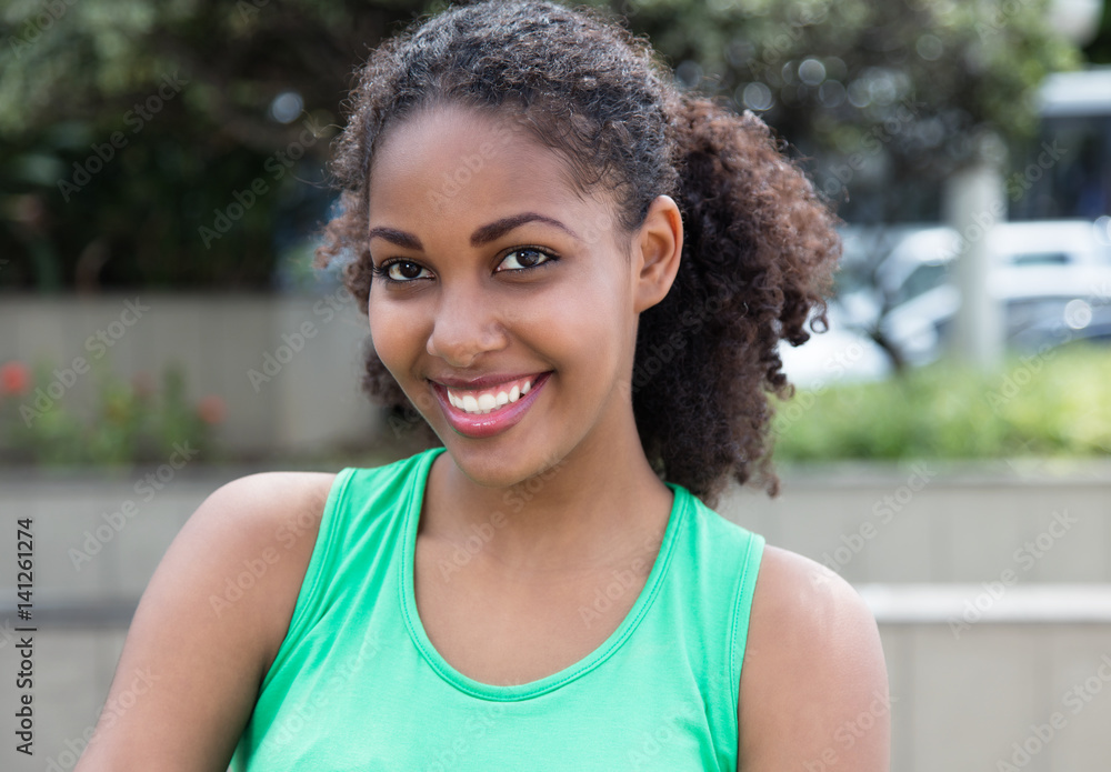 Cute latin woman with curly hair and green in city Cute latin woman with curly hair and green in city