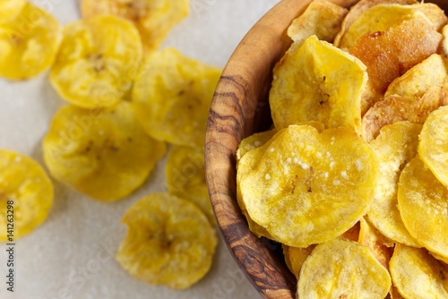 Bilde på lerret Fried plantain chips in a wooden bowl.