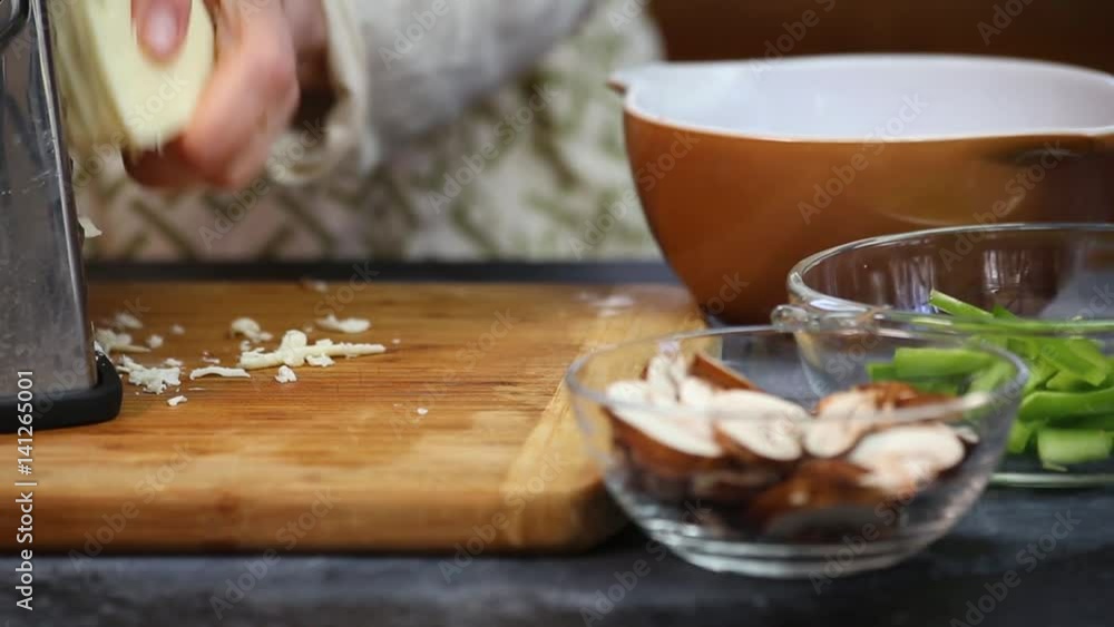 Shredding and grating mozzarella cheese for a home made pizza. Stock