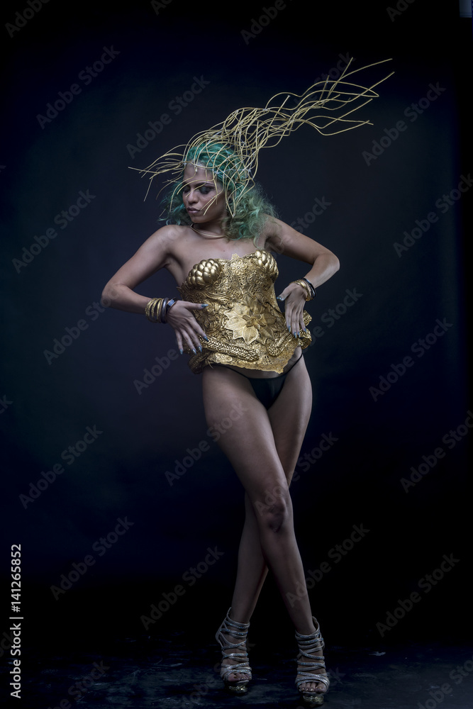 Sexy Latin woman with green hair and gold costume with handmade flourishes, fantasy image and tale
