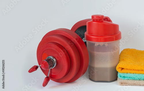 Fitness lifestyle concept. Dumbbell, towels, shaker with whey protein
