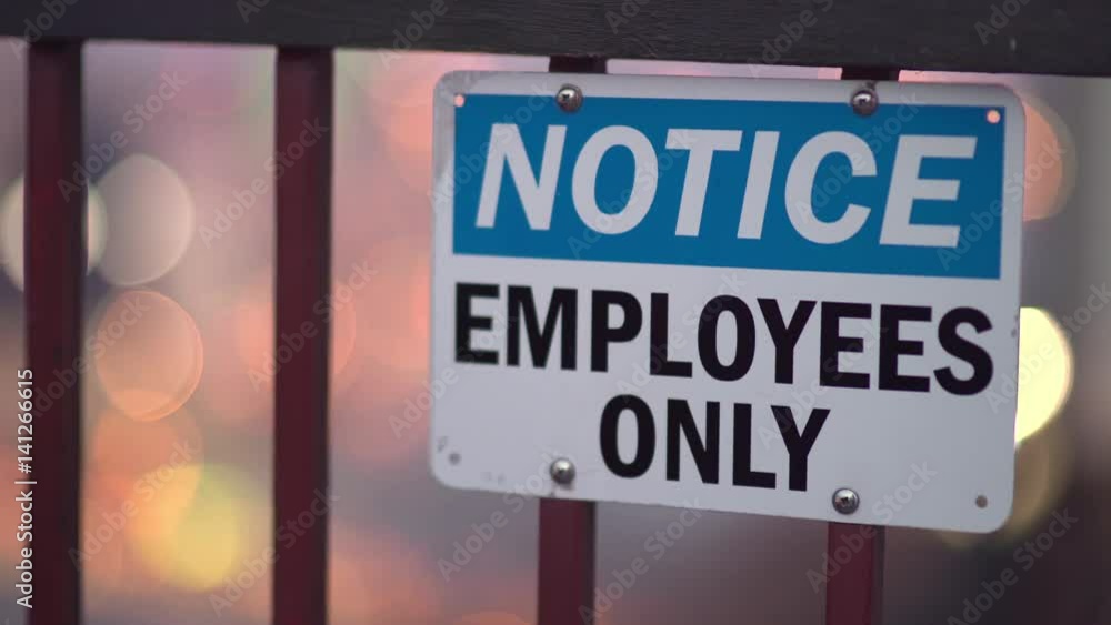 Sign letting people know that this entrance is for employees only, with city night background.
Sign letting people know that this entrance is for employees only, with city night background.