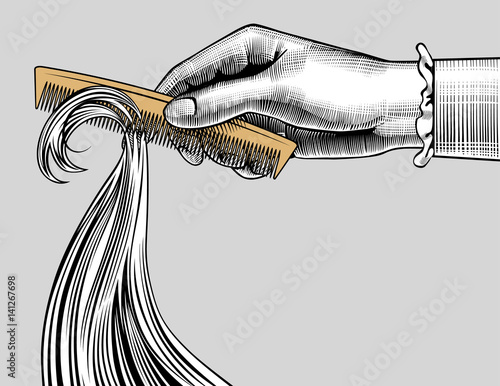 Woman's hand combing hair with a retro comb