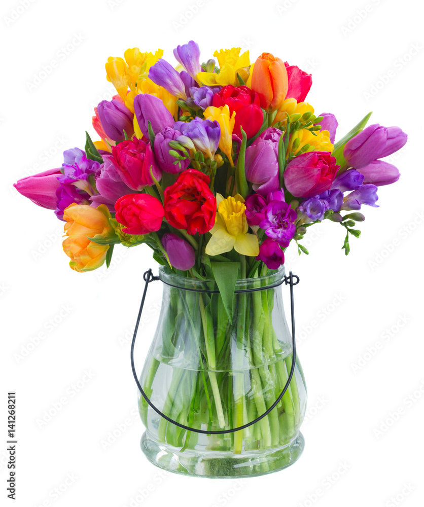 bouquet of bright spring flowers in glass vase isolated on white background