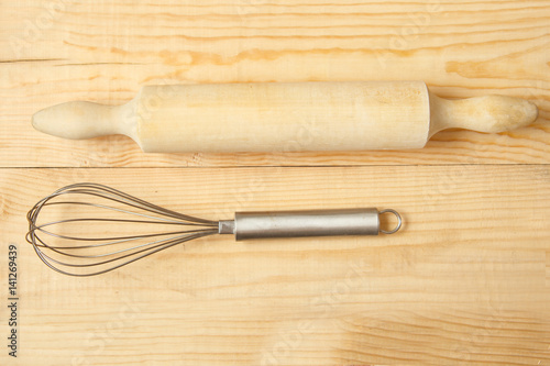 rolling pin and whisk on wooden photo