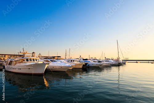 Commercial port of yachts and motor boats in Black sea at sunset.