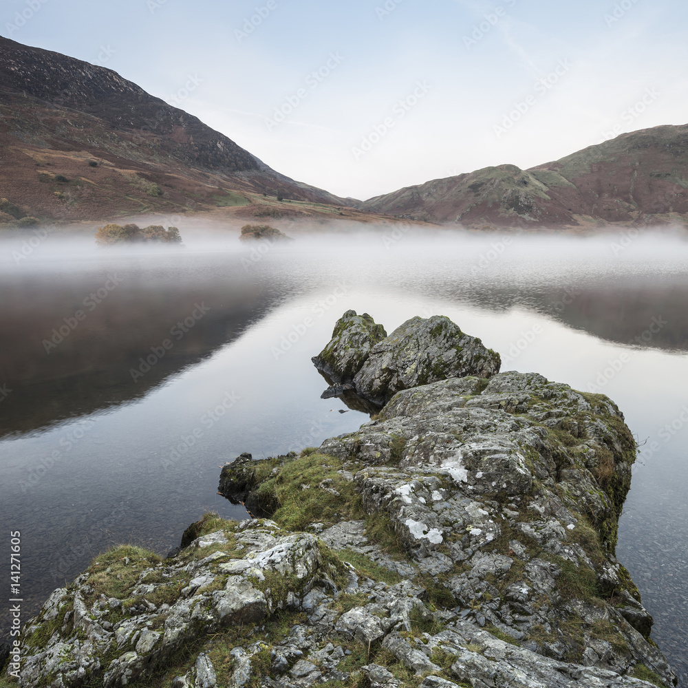 Fototapeta premium Stunning Winter foggy sunrise on Crummock Water in Lake District England