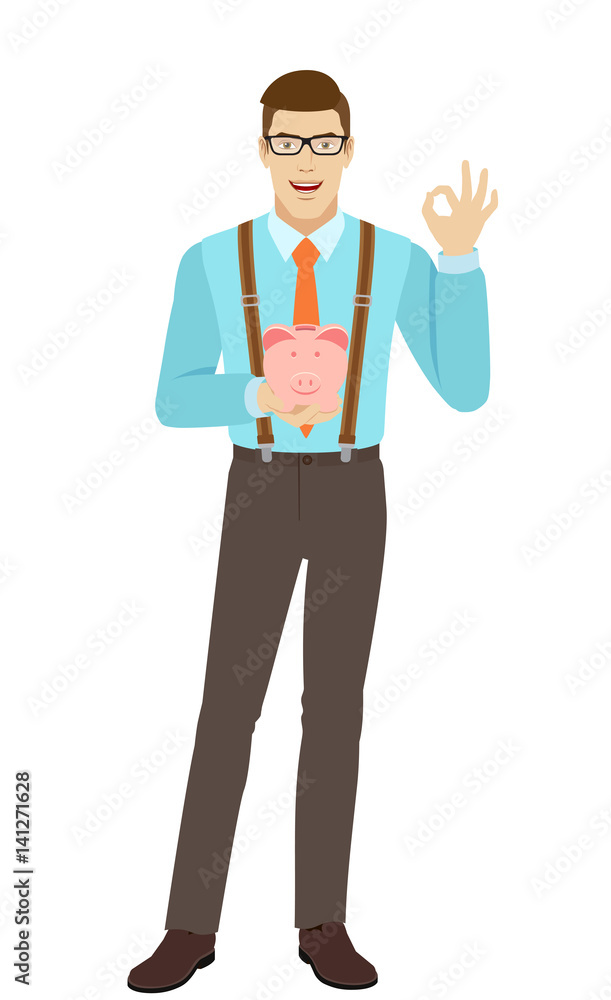 Businessman holding piggy bank and showing a okay hand sign