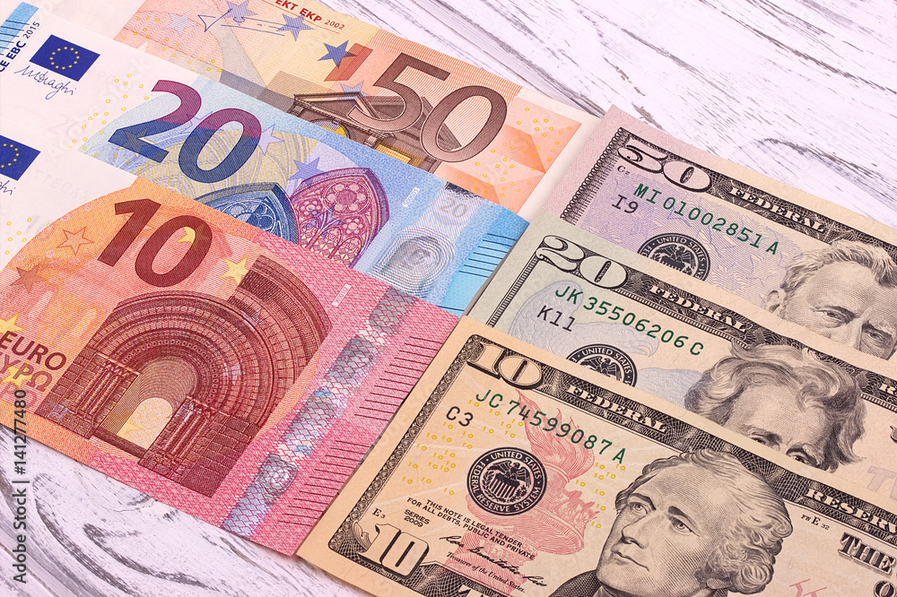 Money background american dollars and euro different denominationson old white wooden plank.