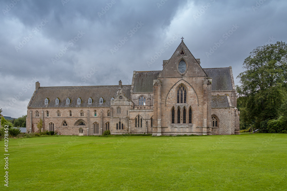 Pluscarden Abbey in Scotland with green grass and trees