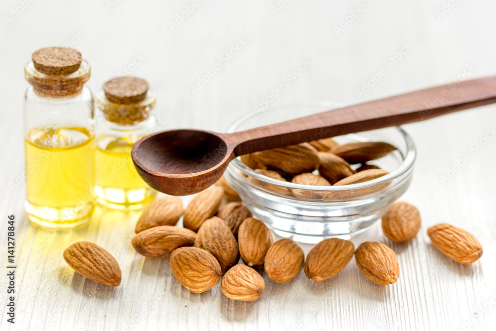 cosmetic and therapeutic almond oil on light wooden background cosmetic and therapeutic almond oil on light wooden background
