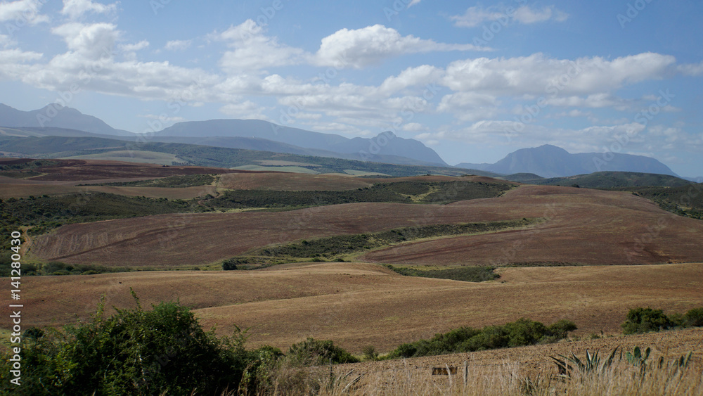Landschaft in Südafrika/ Hügelige Landschaft in der Provinz Westkap in Südafrika im Herbst, Felder und im Hintergrund die Langeberg Mountains, Landschaft in Südafrika/ Hügelige Landschaft in der Provinz Westkap in Südafrika im Herbst, Felder und im Hintergrund die Langeberg Mountains,