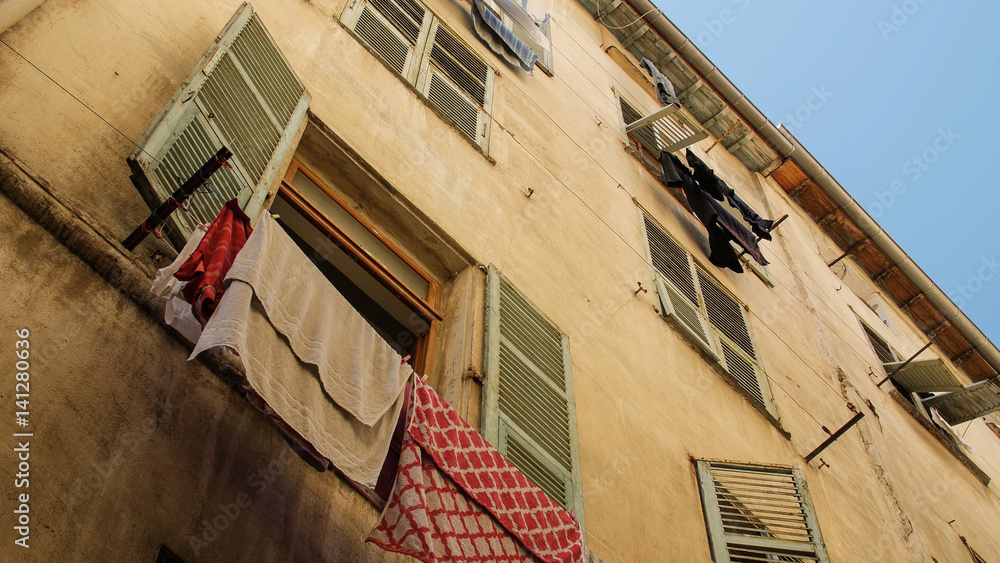 Exterior of buildings in Europe with clothes hanging from window. Nice, France.