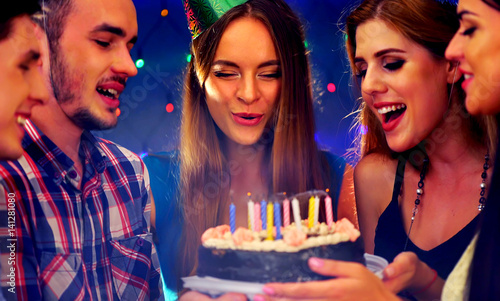 Happy friends birthday celebrating food with celebration cakes. Meet people wear in hat party blow out candles at burning candles. Time of night fun for women and men in nightclub together.