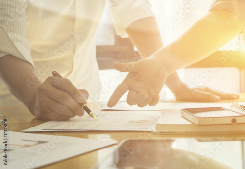 New startup business project,Business meeting time,account managers crew working with new startup project,pointing hands,Laptop Notebook on wood table.analyze plans,vintage tone,morning light flare