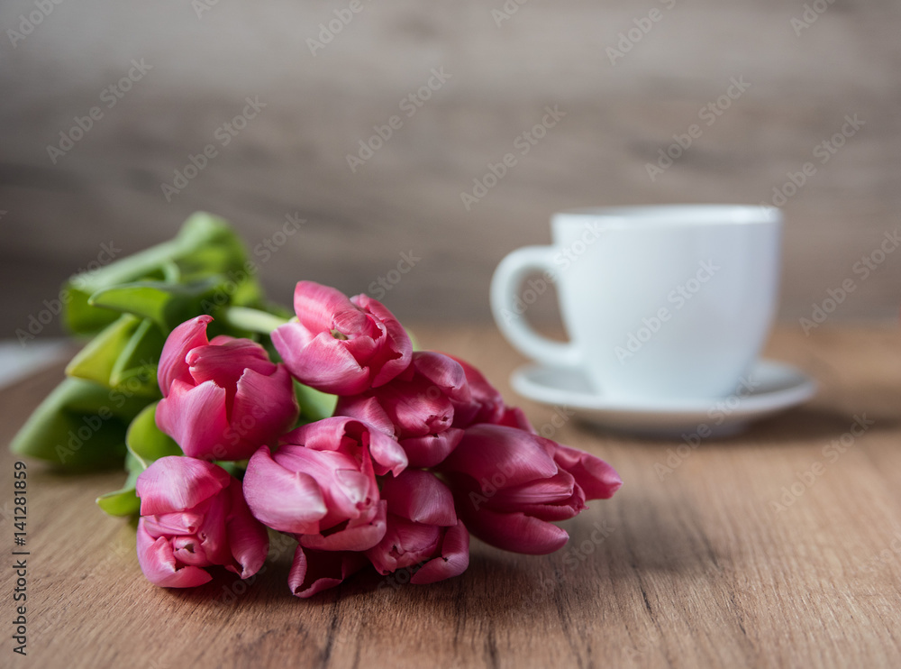 coffee cup with tulips on wooden back ground coffee cup with tulips on wooden back ground