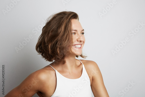 Portrait of smiling young woman. Isolated over white background.