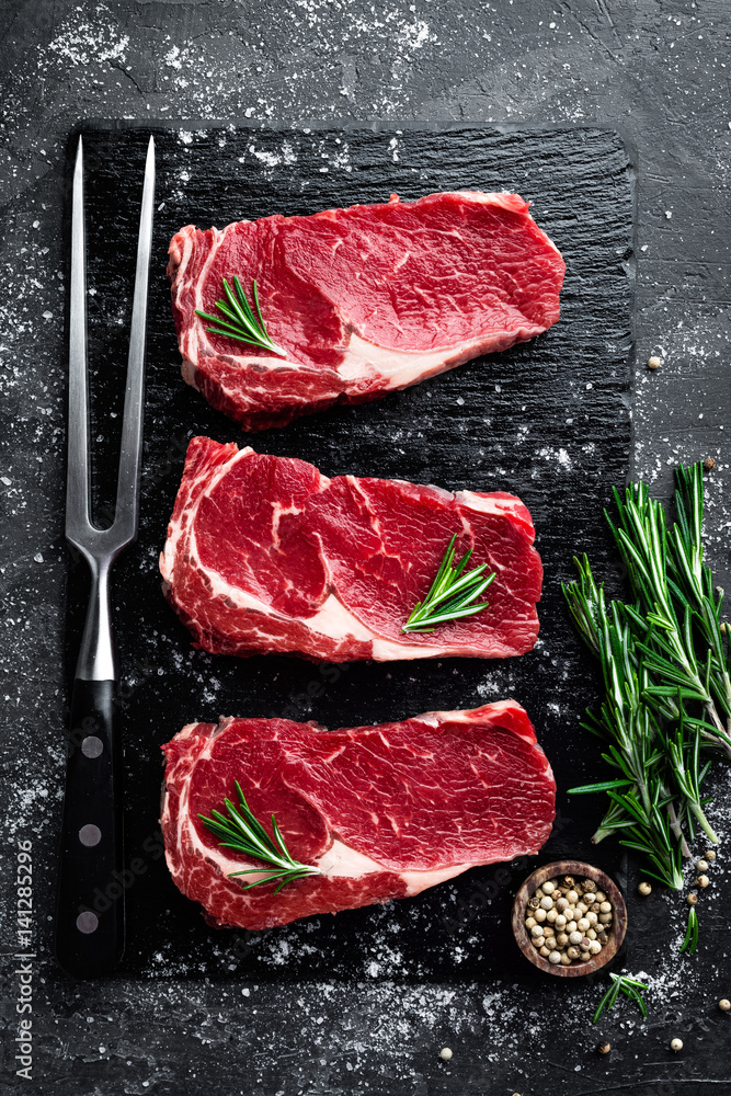 Raw meat, beef steak on black background, top view - obrazy, fototapety, plakaty 