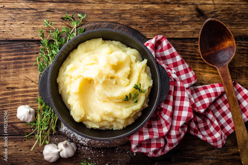 Fotótapéta Mashed potatoes, boiled puree in cast iron pot on dark wooden rustic background,