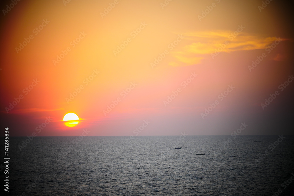 Obraz premium Bougainvillea and Orange Sunset above ocean Kerala