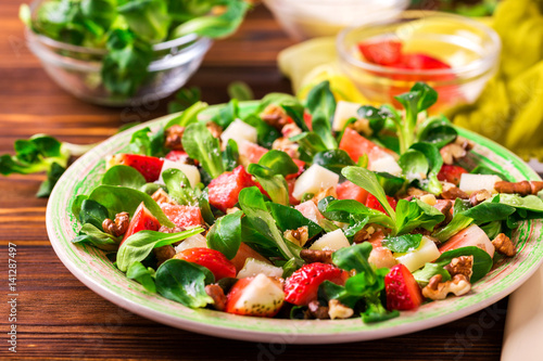 Salad with strawberry, spinach, walnuts and goat cheese