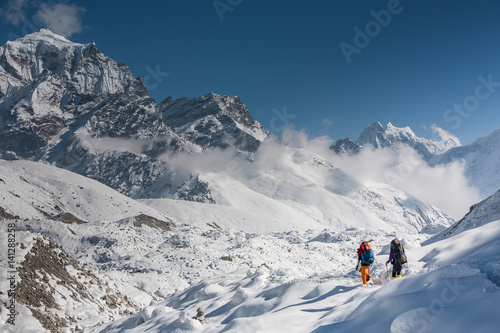 Trekkers crossing Gokyo glacier in Khumbu valley on a way to Everest Base camp