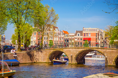 Traditional old buildings and and boats in Amsterdam, Netherlands. Canals of Amsterdam.