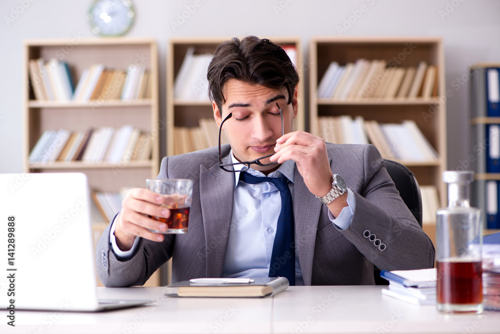 Young businessman drinking from stress Young businessman drinking from stress