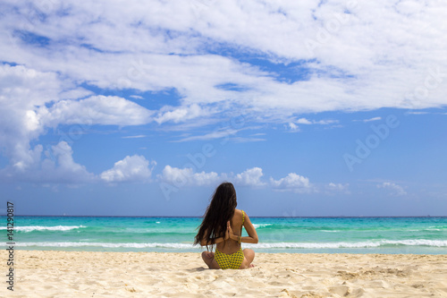 Woman practicing meditation on the beach