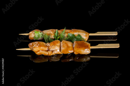 Pork cooking on a grill. On a black background with reflection