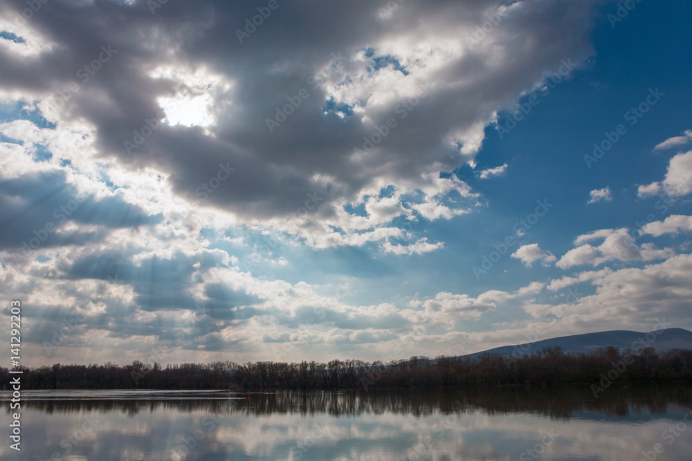 Tranquil scenery of a river with nice cloudscape and sunbeams