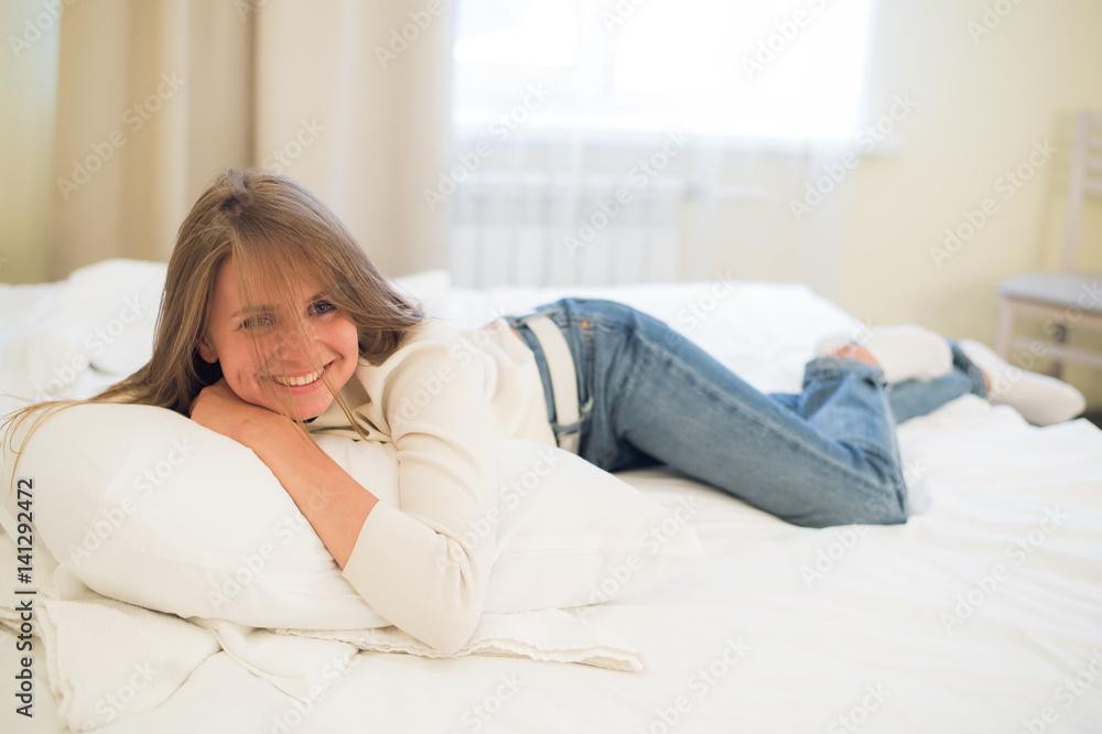Smiling thoughtful pretty woman lying in bed at home Smiling thoughtful pretty woman lying in bed at home